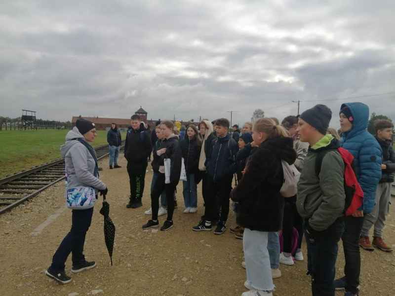 Zwiedzanie drugiej części obozu czyli KL Auschwitz II (Birkenau) przez uczniów klasy 8. Uczniowie stali przed torami kolejowymi