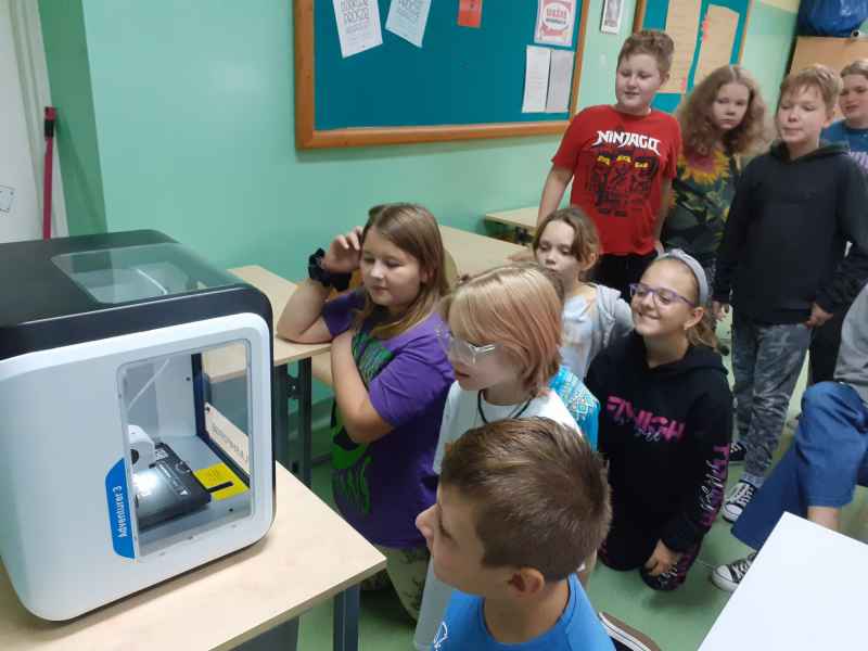 Uczniowie obsługują panel drukarki 3D